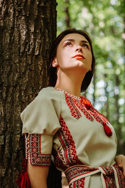 Фото Вертикальное изображение женщины, одетой в традиционную модную украинскую вышитую рубашку-вышиванку
