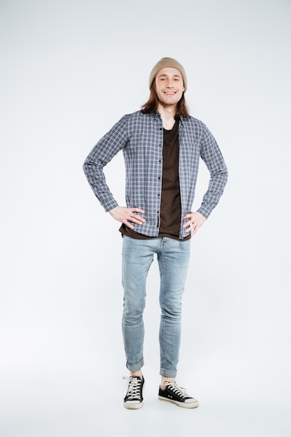 Vertical image of Smiling hipster with arms on hip