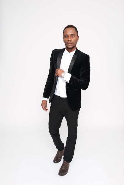 Vertical image of young african man in suit. Full length. Isolated white background