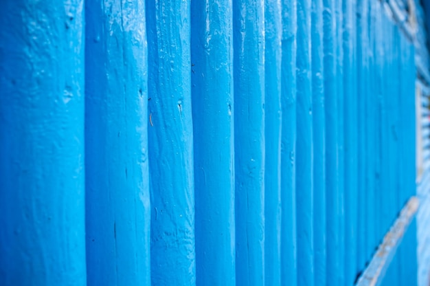 Vertical log wall in blue outdoors wooden building