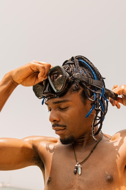 Vertical photo of afro latin man putting himself the diving googles