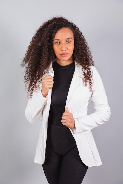 Vertical photo beautiful black Brazilian woman businesswoman wearing white suit facing camera