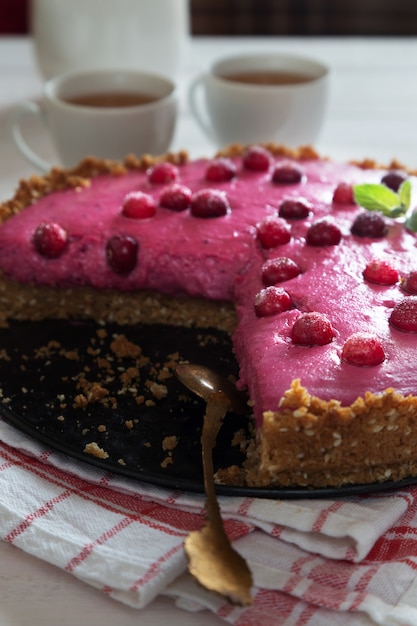 Vertical photo of cranberry cake with berries and mint and spoon