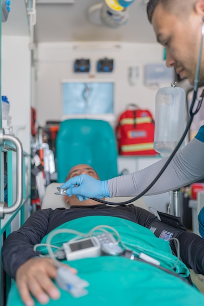 Вертикальное фото врача, проверяющего сердцебиение пациента в машине скорой помощи