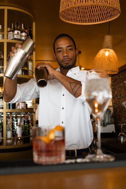 Vertical photo of a latin bartender mixing alcohol for cocktails