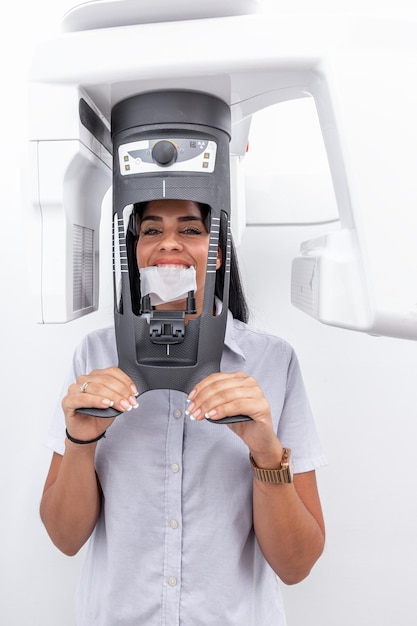 写真 歯科クリニックの歯磨き機に顔を入れた女性クライアントの垂直写真