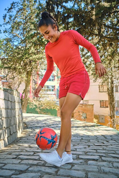 写真 ボリビアラテンアメリカでボールでサッカーをしている若い女性の垂直写真