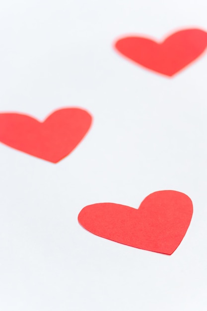 Vertical photo of three paper hearts on white background with copy space