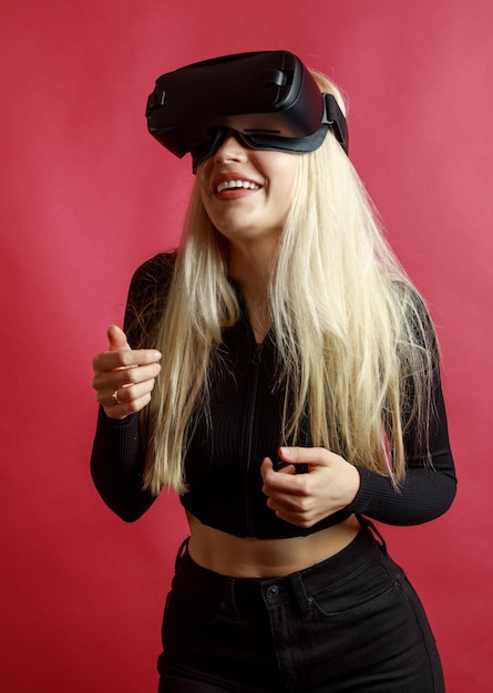 VR 안경을 쓰고 웃고 있는 젊은 금발의 세로 사진