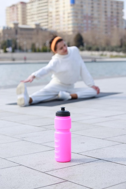 Vertical photo of young lady doing exercises at the park High quality photo