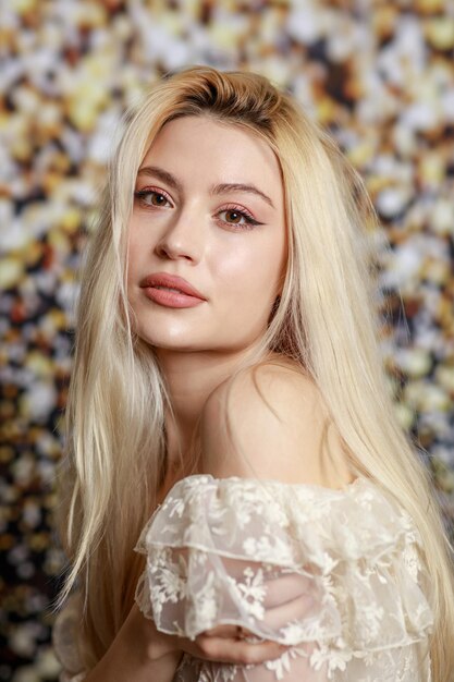 Vertical photo of young lady looking at the camera on gilded background