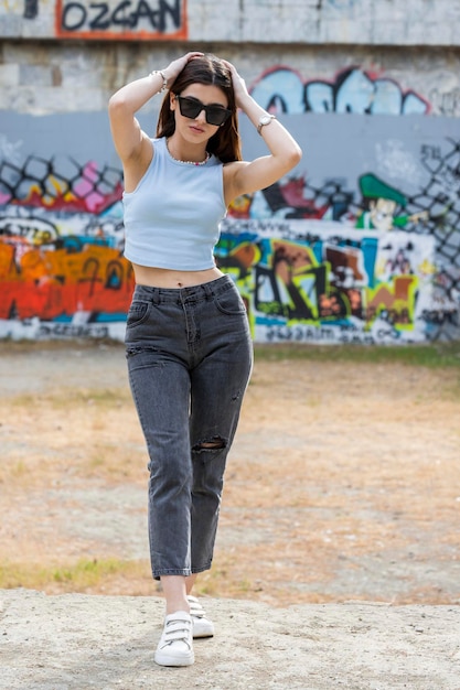 Vertical photo of young lady wearing sunglasses and put her hands on her head