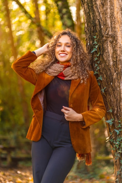 Vertical photo of a young model posing with warm clothes in a park