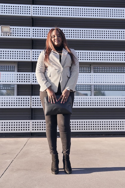 Vertical photograph of an AfricanAmerican woman with the office building behind