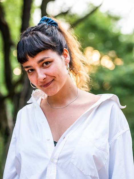 Immagine verticale di una donna bruna con una camicia bianca con un sorriso incredibile