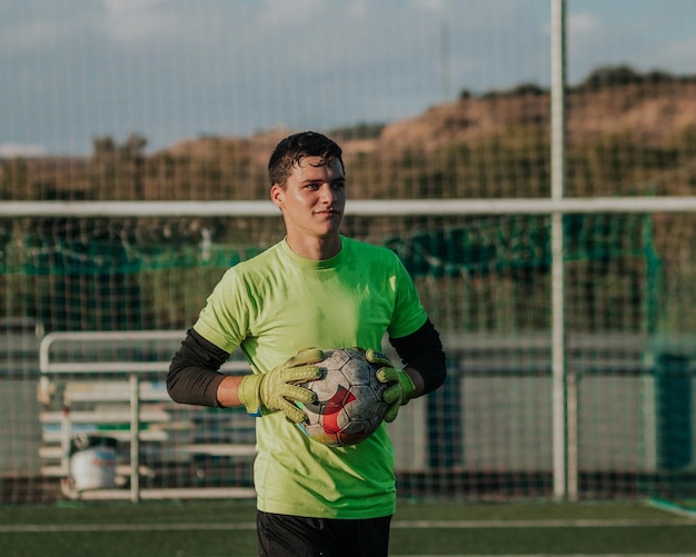 Vertical portait of a goalie holding a soccer ball.