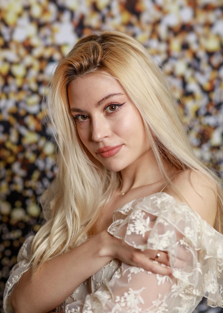 vertical portrait of beautiful lady looking at the camera on gilded background