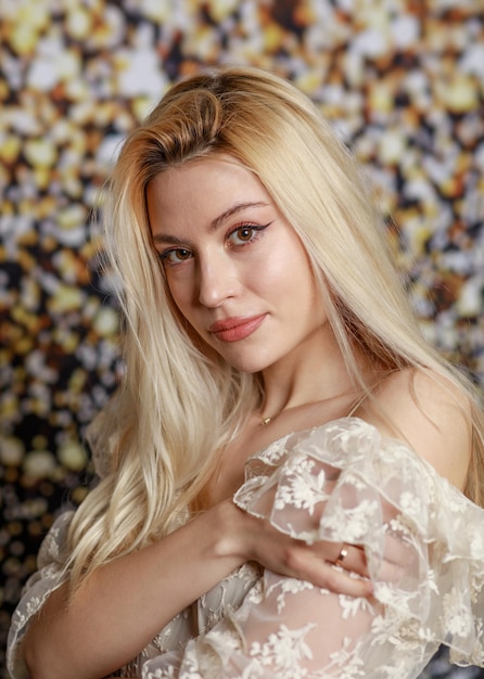 Vertical portrait of beautiful lady looking at the camera on gilded background