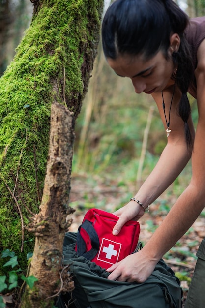 Photo vertical portrait buscraft girl takes first aid kit in wild life
