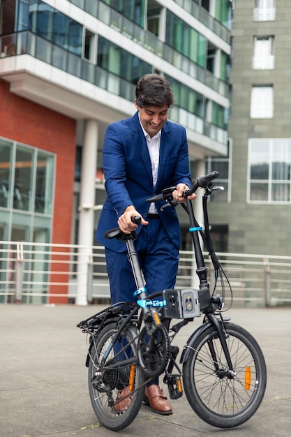 vertical portrait Businessman folding electric folding bike in city financial district