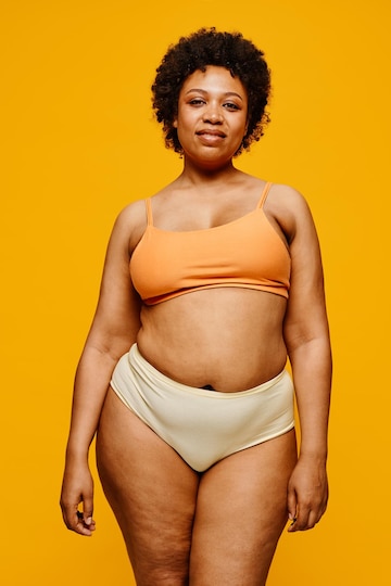 Premium Photo  Vertical portrait of confident black woman wearing underwear  against vibrant yellow background