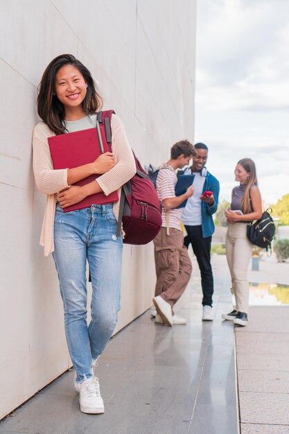 Photo vertical portrait confident young girl at the university looking at camera and holding a folder