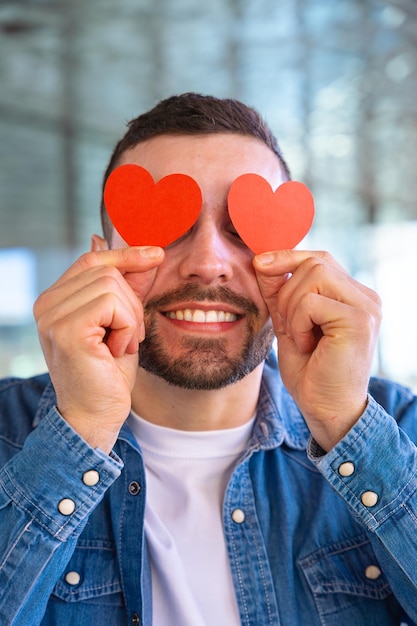 vertical portrait excited young man with hearts in his eyes on valentines day