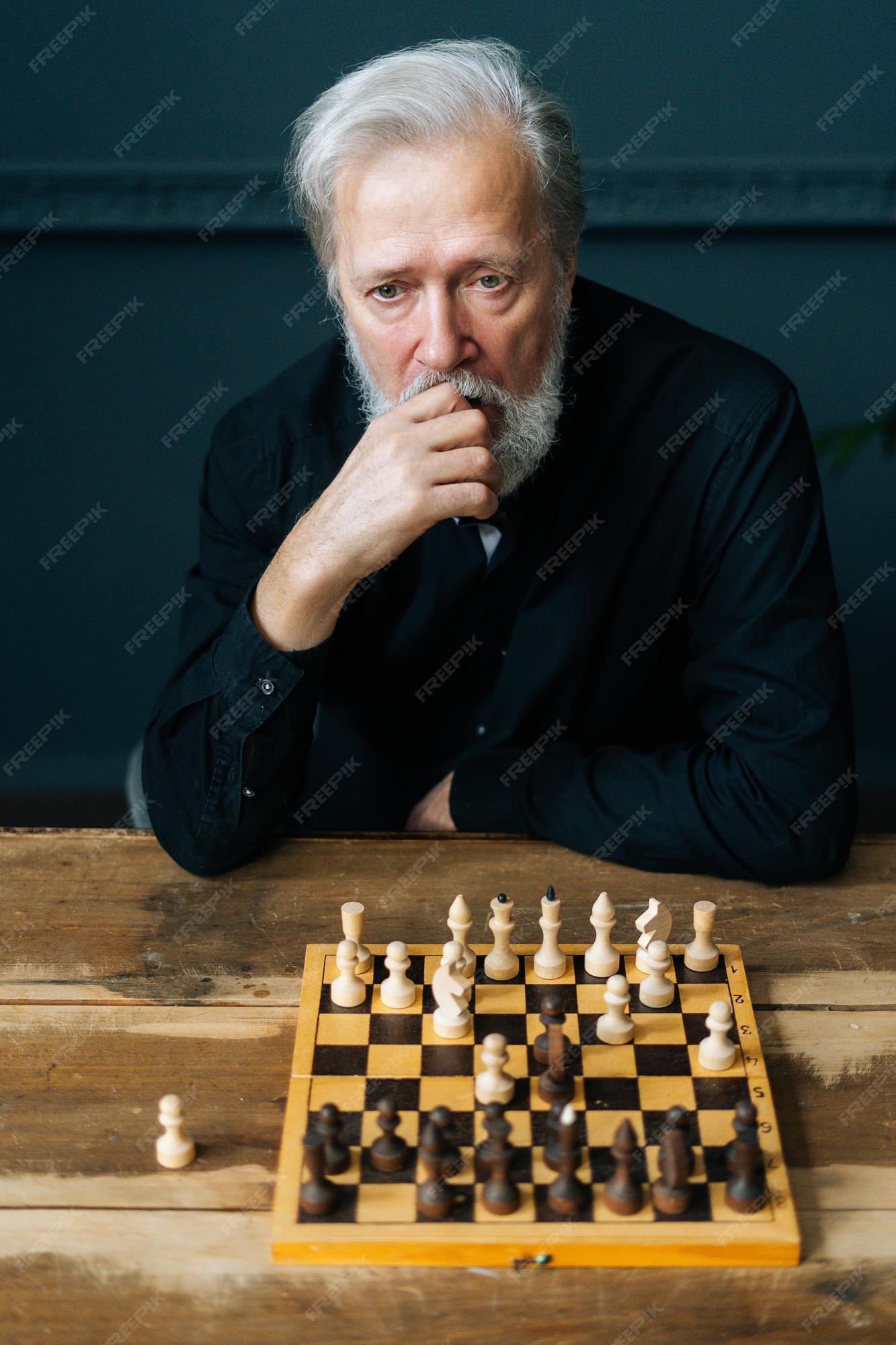 Young pensive man sitting and playing chess online