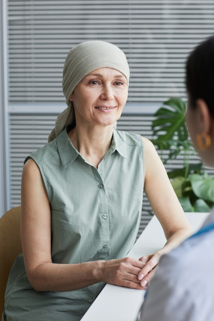 Photo vertical portrait of smiling mature woman talking to female doctor during consultation in medical clinic