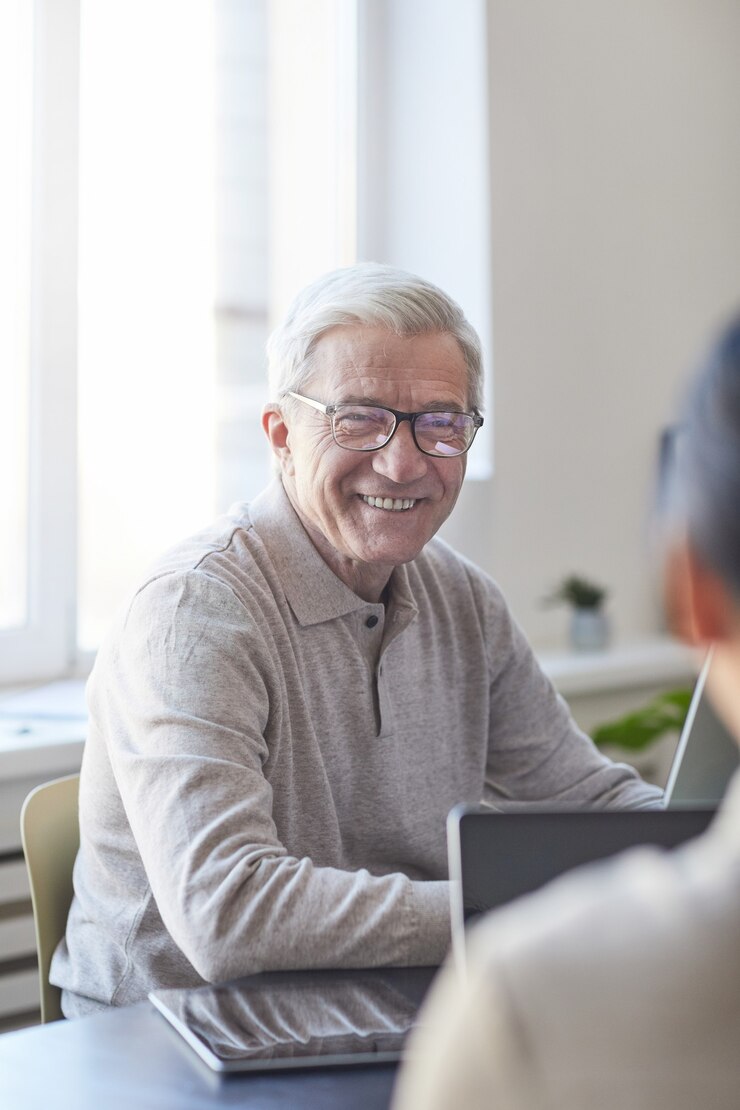 Photo vertical portrait of smiling senior man collaborating with young people in modern office, career change concept