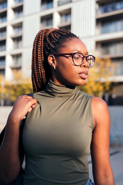 Vertical portrait of a young african student with glasses, concept of youth and urban lifestyle