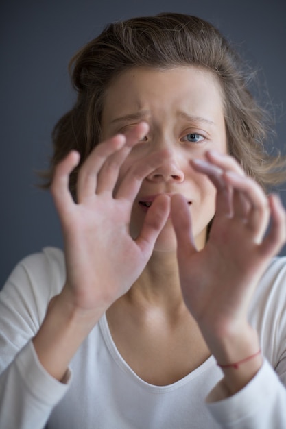 Vertical portrait of young frightened lady sadly 