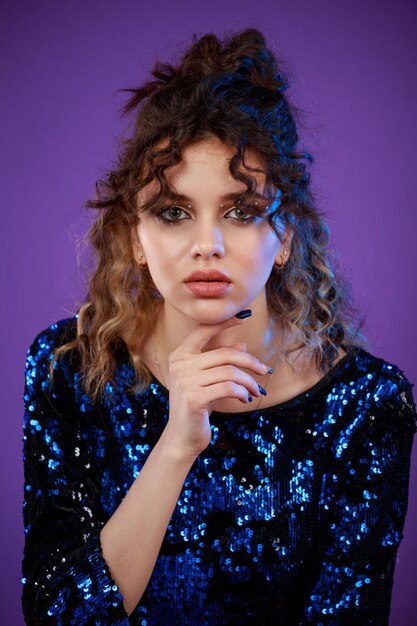 Vertical portrait of young lady out her finger to her chin and looking at the camera High quality photo