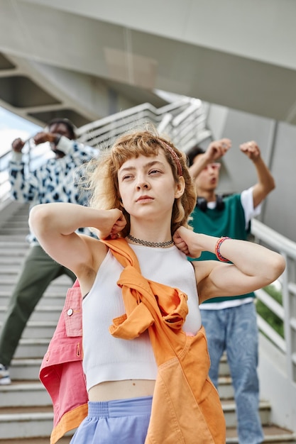 Vertical portrait of young street dance team with focus on\
young woman in foreground