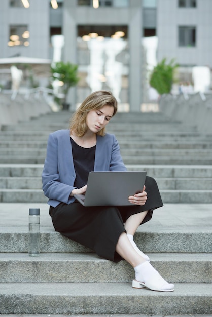 Vertical potrait of a concentrated young businesswoman working at her laptop