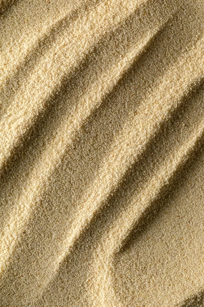 Vertical sandy light background format 23 with waves of sand macro