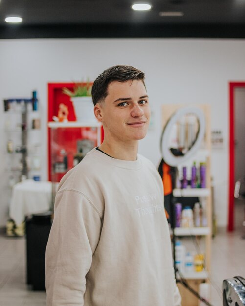 Vertical shoot of a customer looking at the camera after finish his haircut