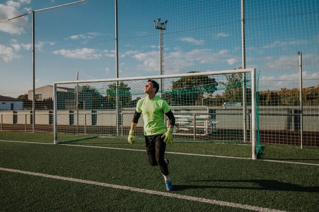 Vertical shoot of a goalkeeper trying stop a shoot.