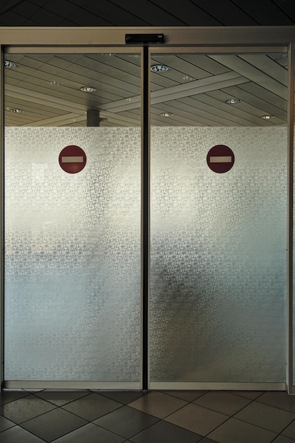 Photo vertical shot of automatic exit glass doors at an airport no access