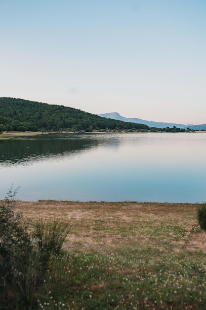 背景に緑の丘がある美しい湖の垂直ショット