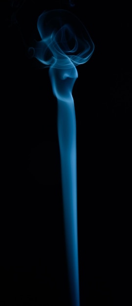 A vertical shot of blue tobacco smoke on a black background