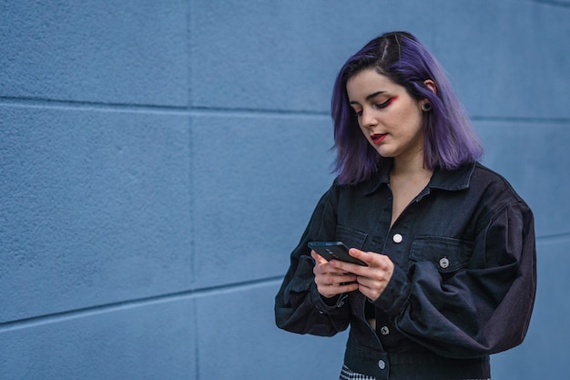 Vertical shot of a Caucasian woman with purple hair chatting on the phone