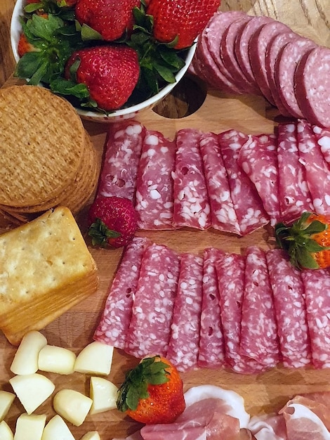 Vertical shot of a  charcuterie board with delicious snacks under the light