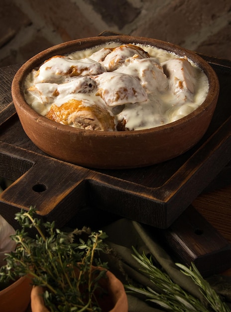 Vertical shot of a chicken covered in a creamy sauce