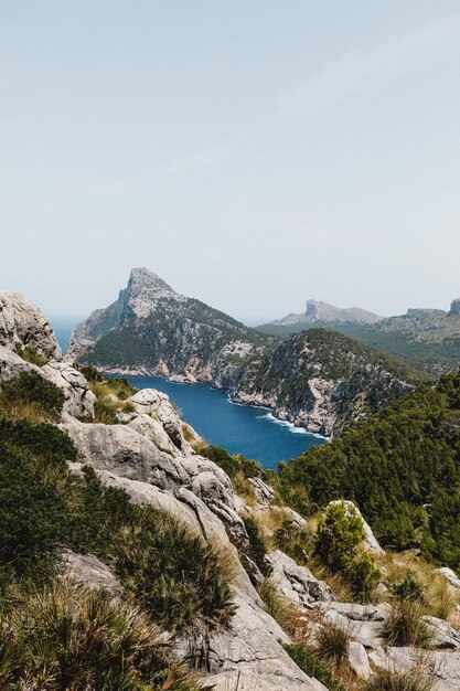 Vertical shot of the cliffs and the blue sea Mirador Es Colomer Spain