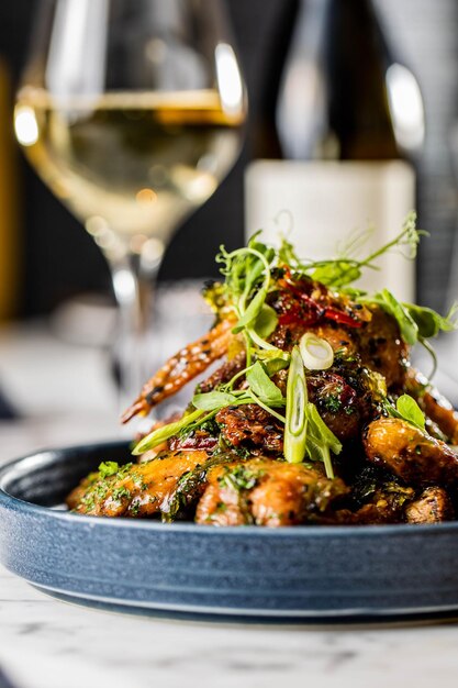 Vertical shot of a delicious meat dish with white wine on the background in a fancy restaurant