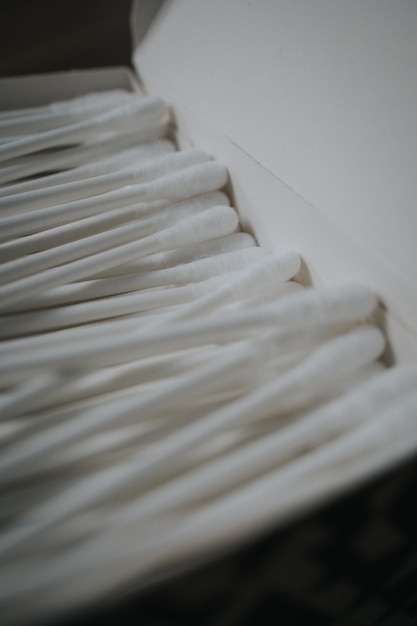 Вертикальный снимок ушных палочек на белой коробке