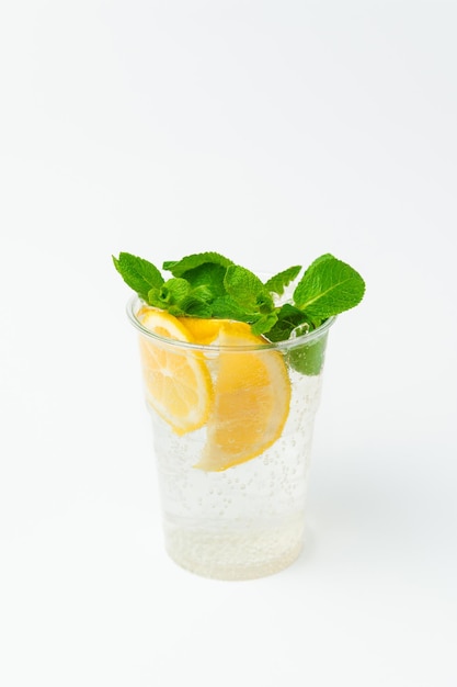 Vertical shot of a fresh lemonade in a to go plastic glass with mint leaves