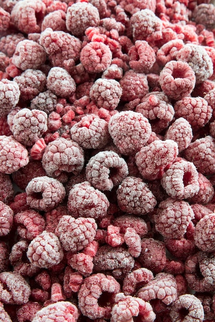 Vertical shot of frozen raspberries under the lights