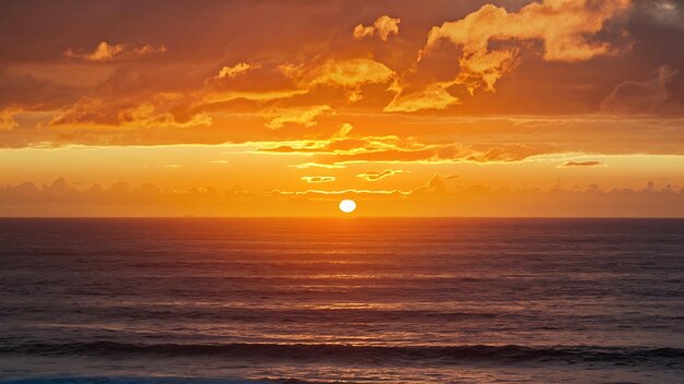 Vertical shot of the golden sunset sky over the pacific ocean